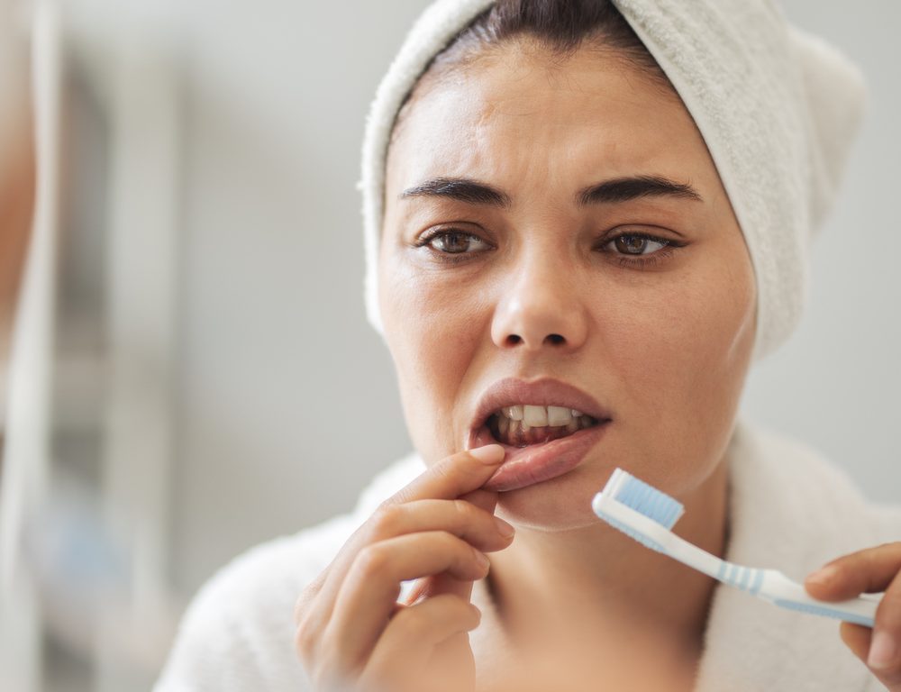 Young woman looking at her red bleeding gums
